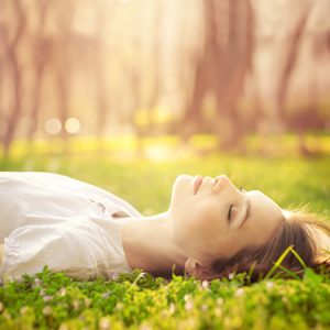 芝生の上で寝そべる女性